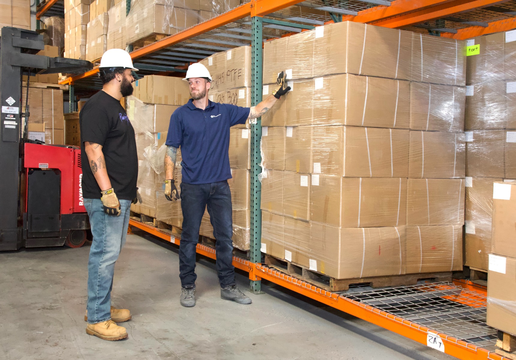 two men in a warehouse with hard hats